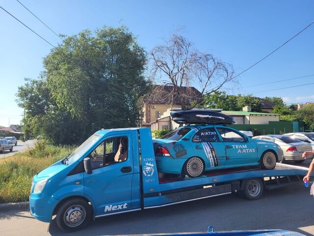 Эвакуатор перевозит гоночный автомобиль